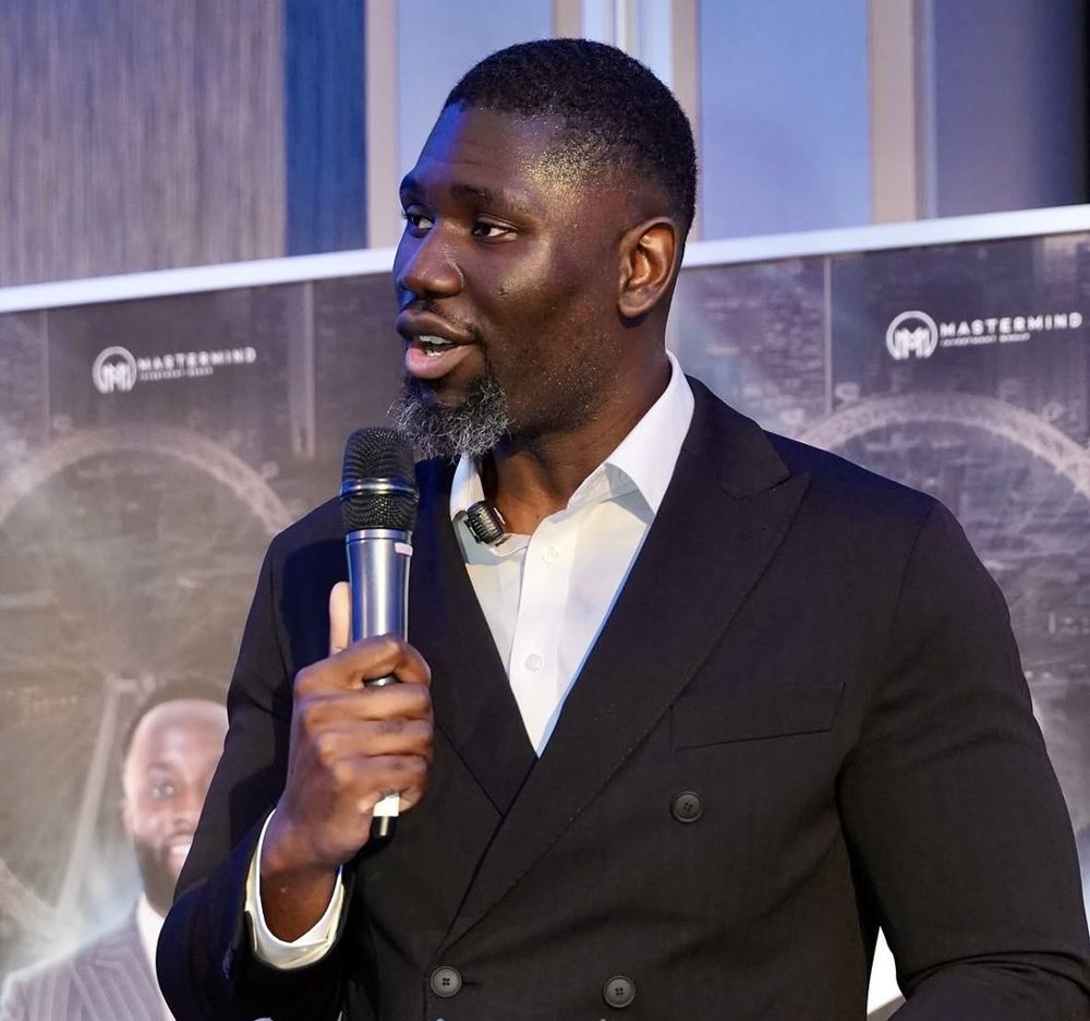 Jason Agbodza holding a microphone on stage